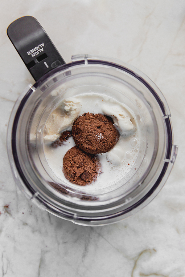 Almond milk, dairy free ice cream and gluten free cookies in a ninja creami cup.