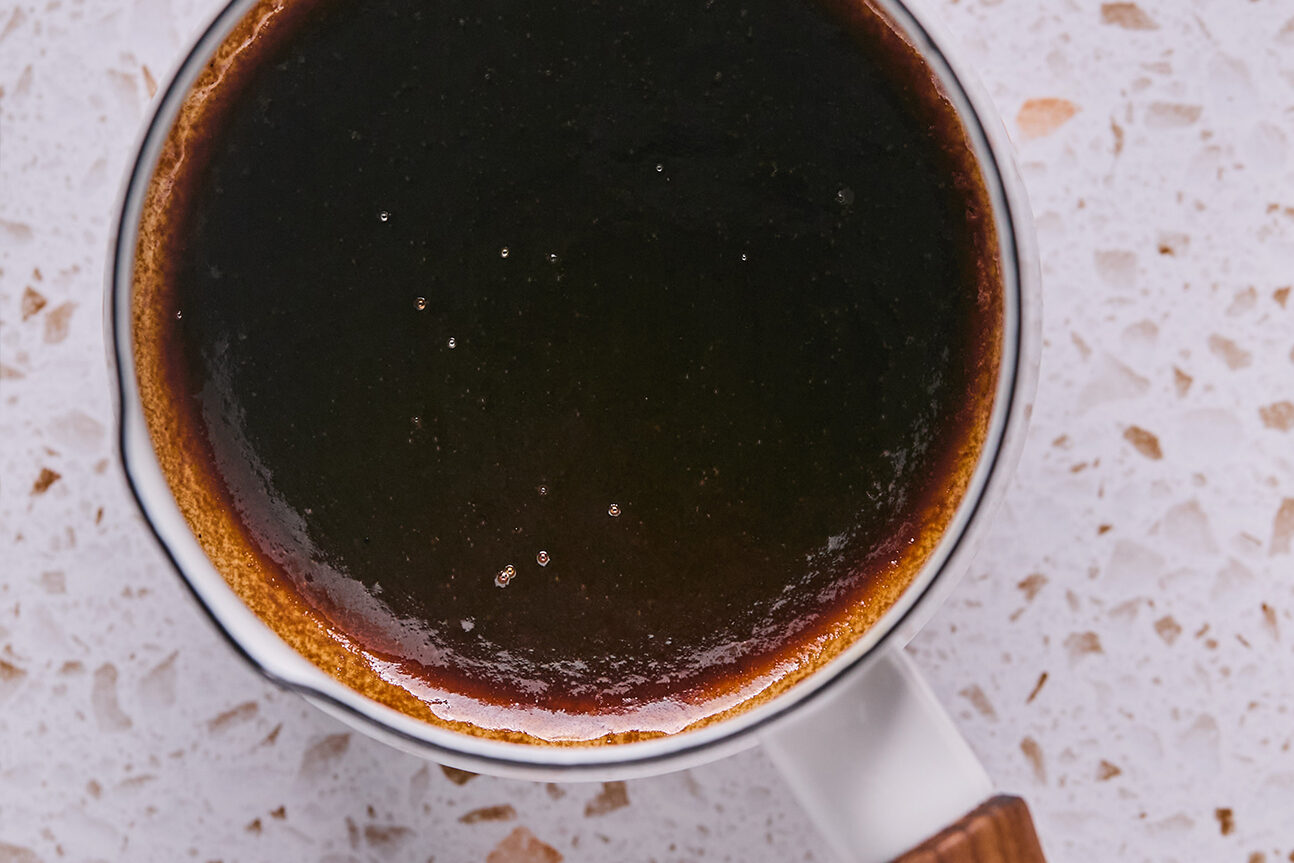 Coconut cream, sugar, and salt in a saucepan after being cooked into a caramel.