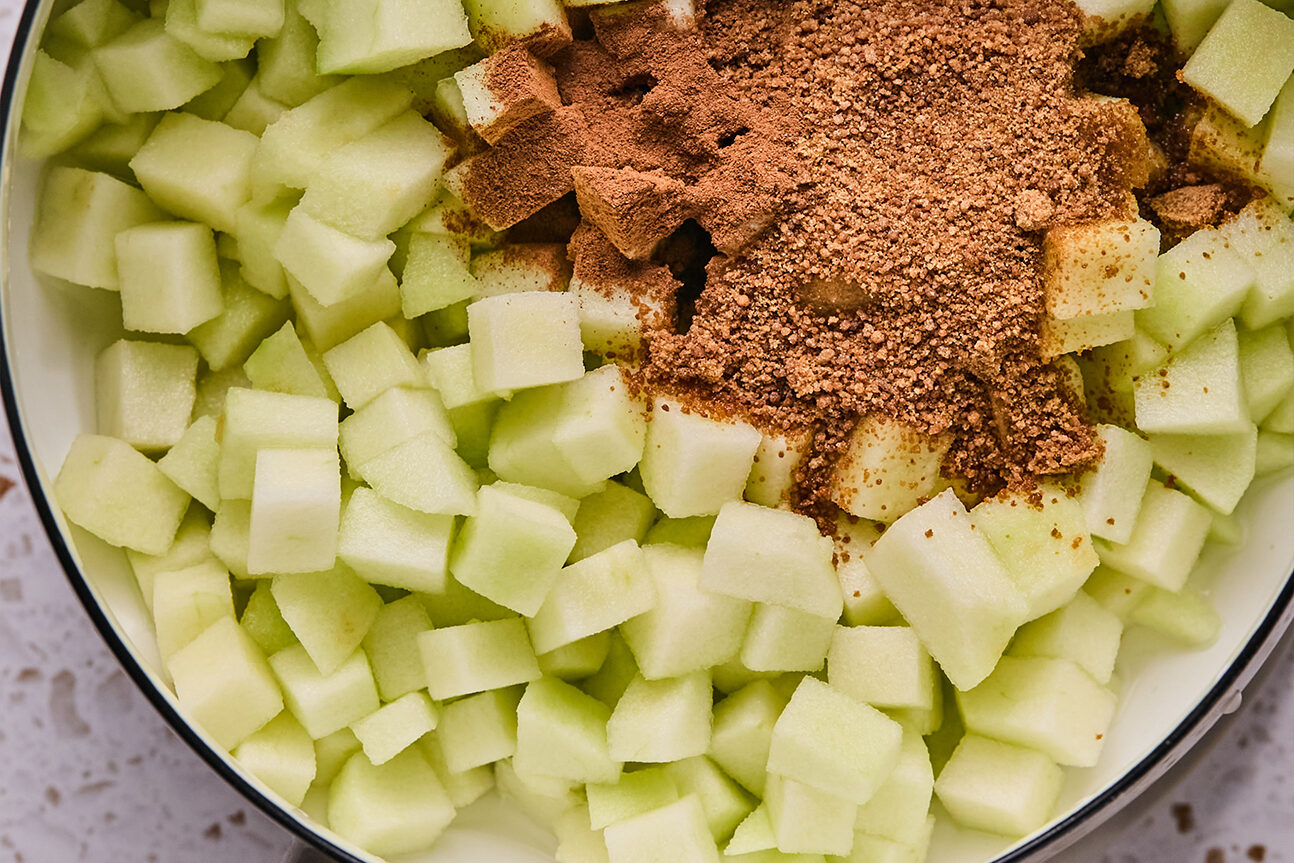 Chopped apple and coconut sugar, ready to be mixed and cooked in a pot.