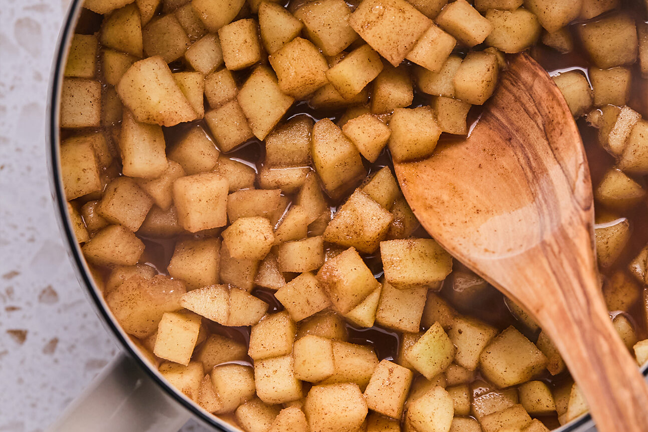 Chopped apple and coconut sugar stewed in a pot.