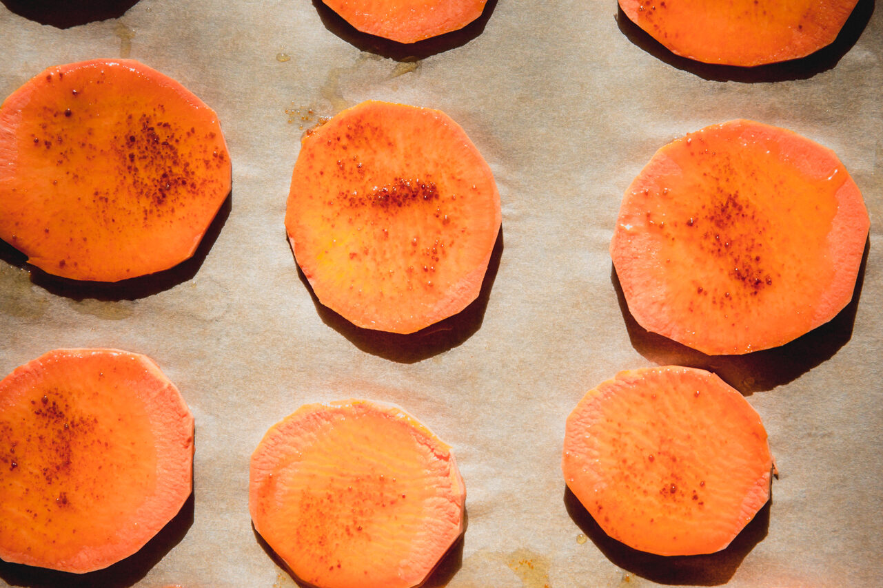 mini sweet potato slices in small rounds on a baking sheet.