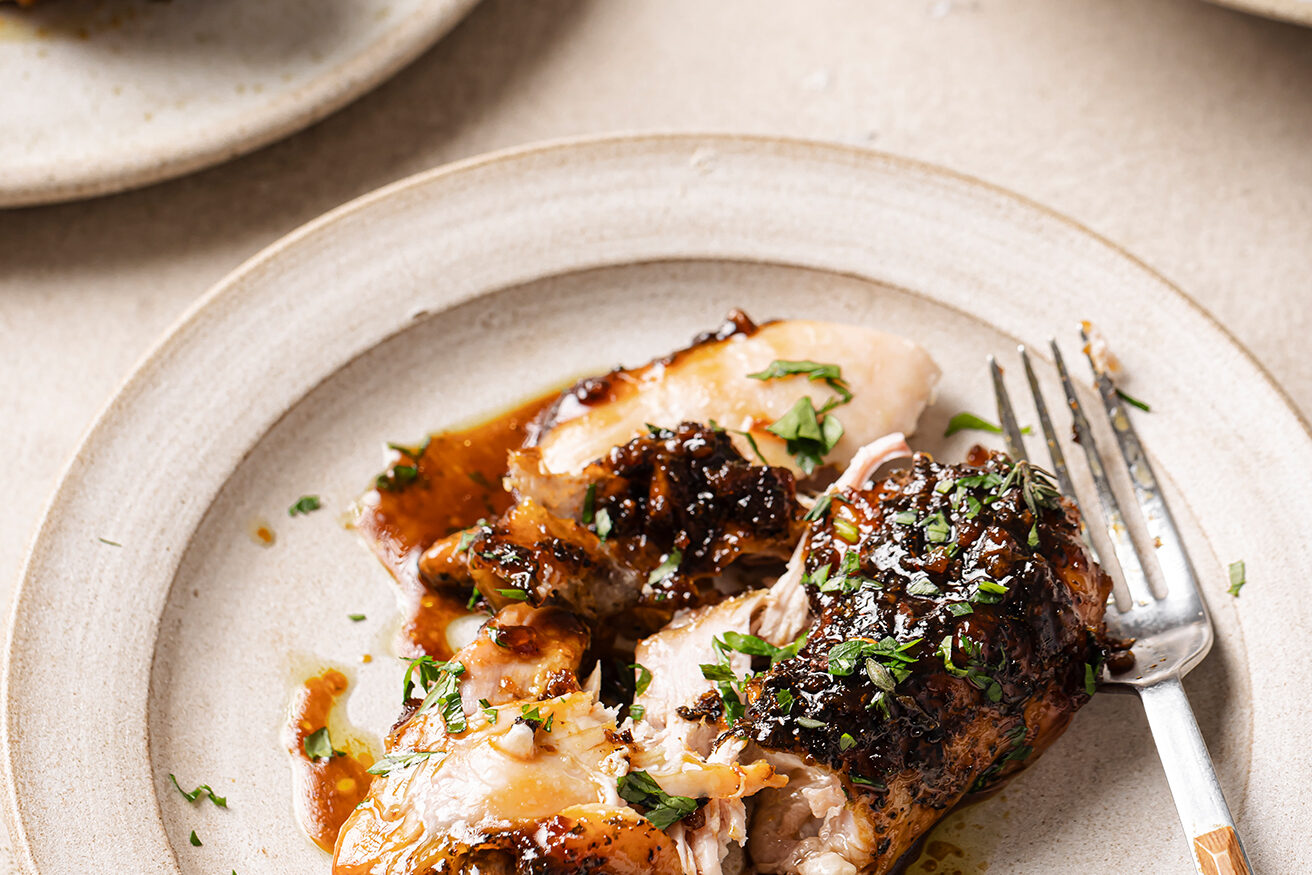One turkey wing on a plate with a fork.