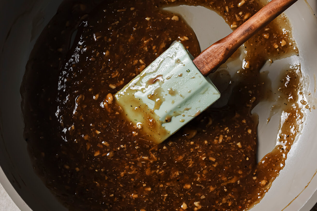 Teriyaki style sauce cooked in a pan with a spatula.