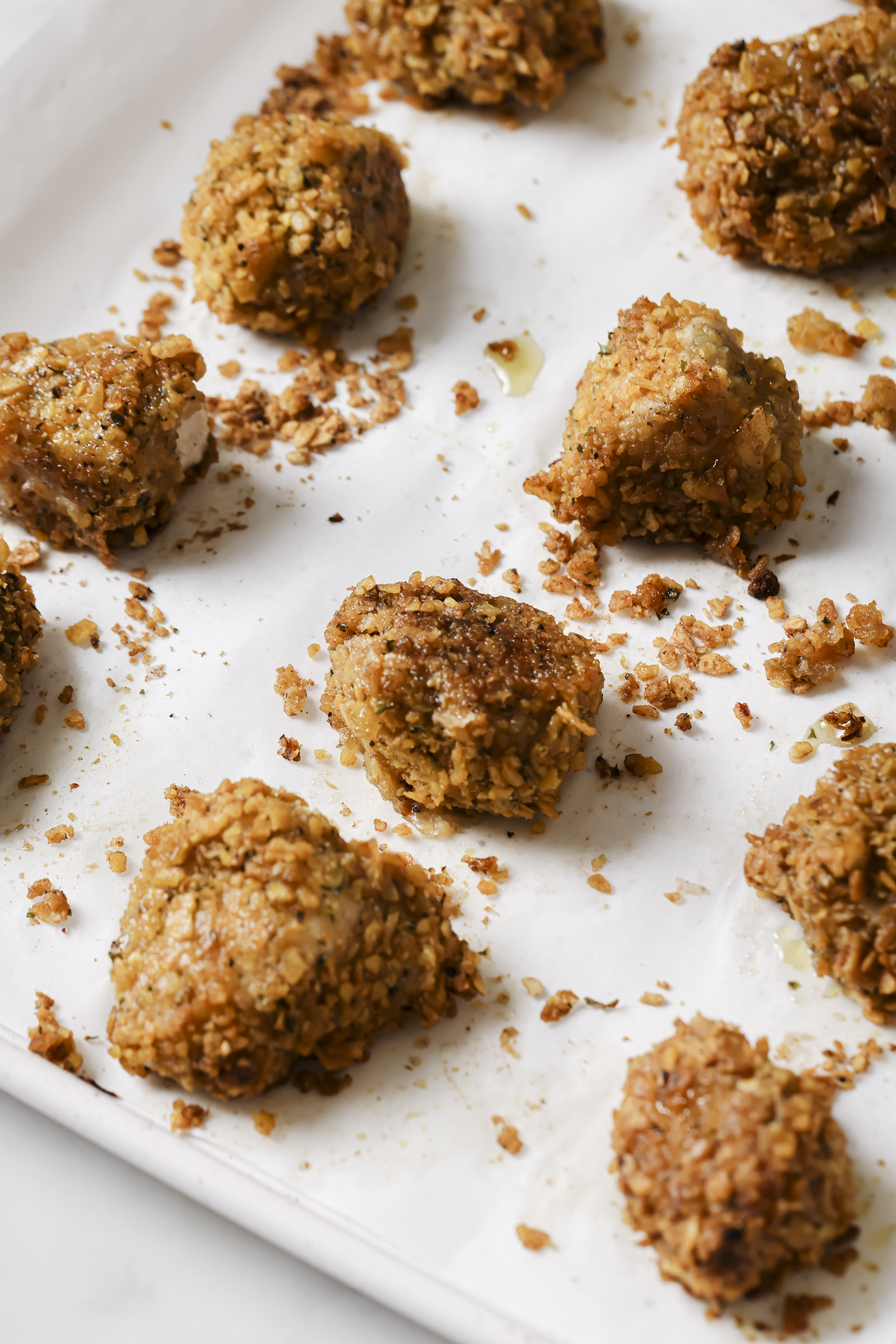 baked crispy chicken nuggets on a parchment lined baking sheet
