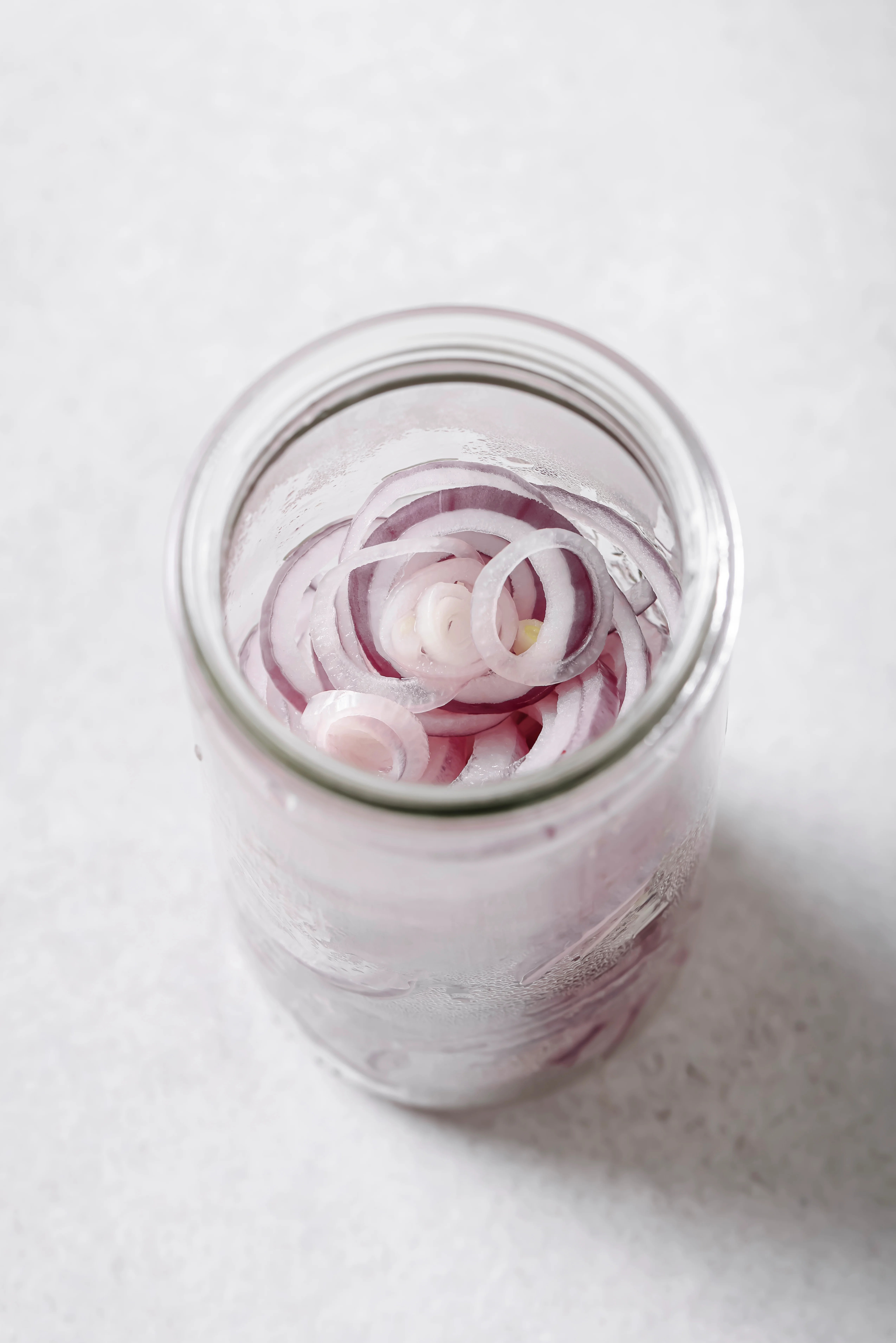 softened red onions in a jar