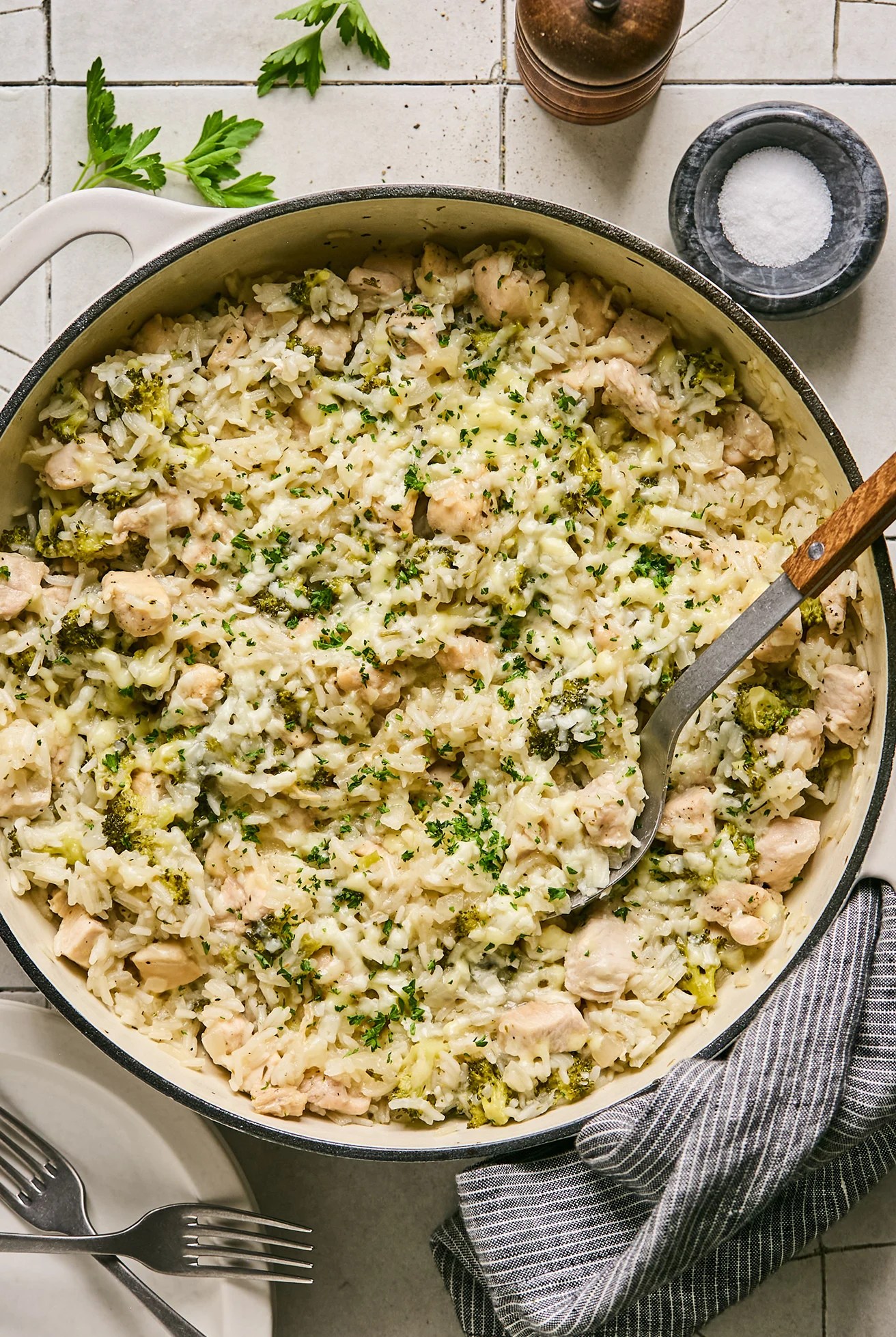 One pot broccoli cheddar chicken and rice served in a large cast iron pot, fully cooked.
