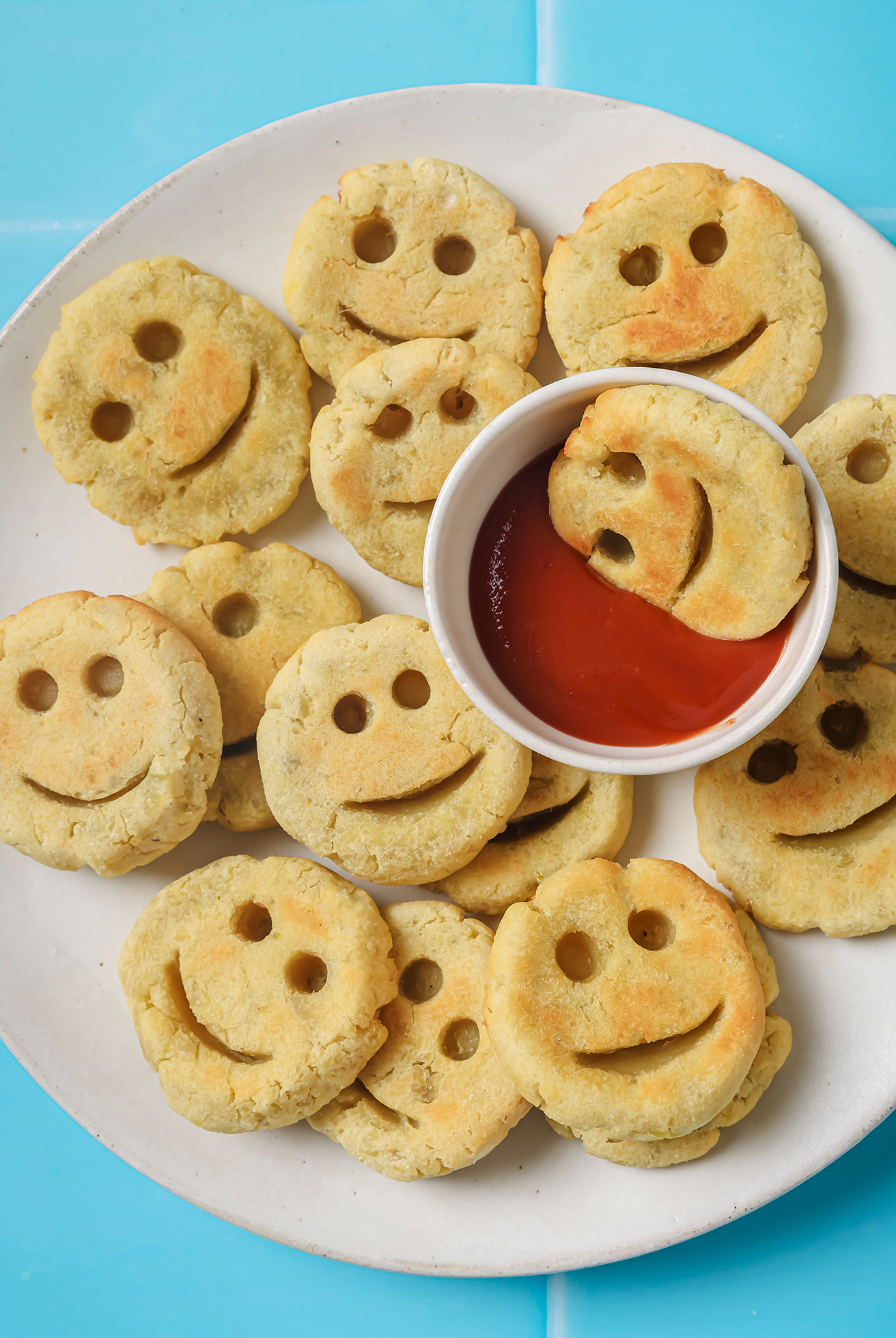 Potato smiley fries on a plate with sauce.