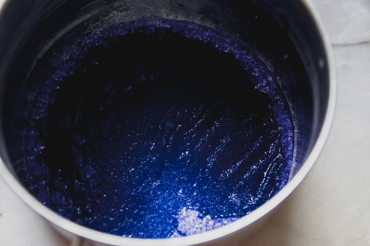 Blue spirulina and apple juice in a pot.