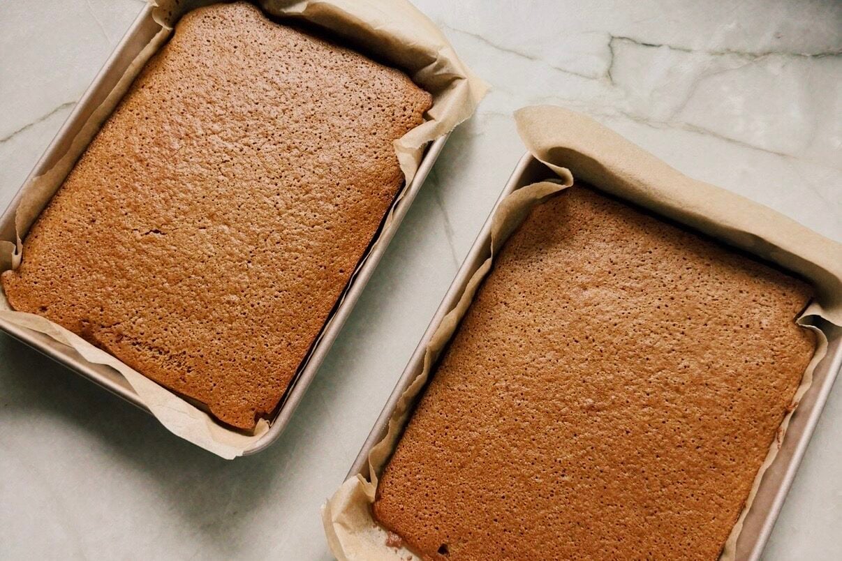 Two rectangular cake pans with baked cake.