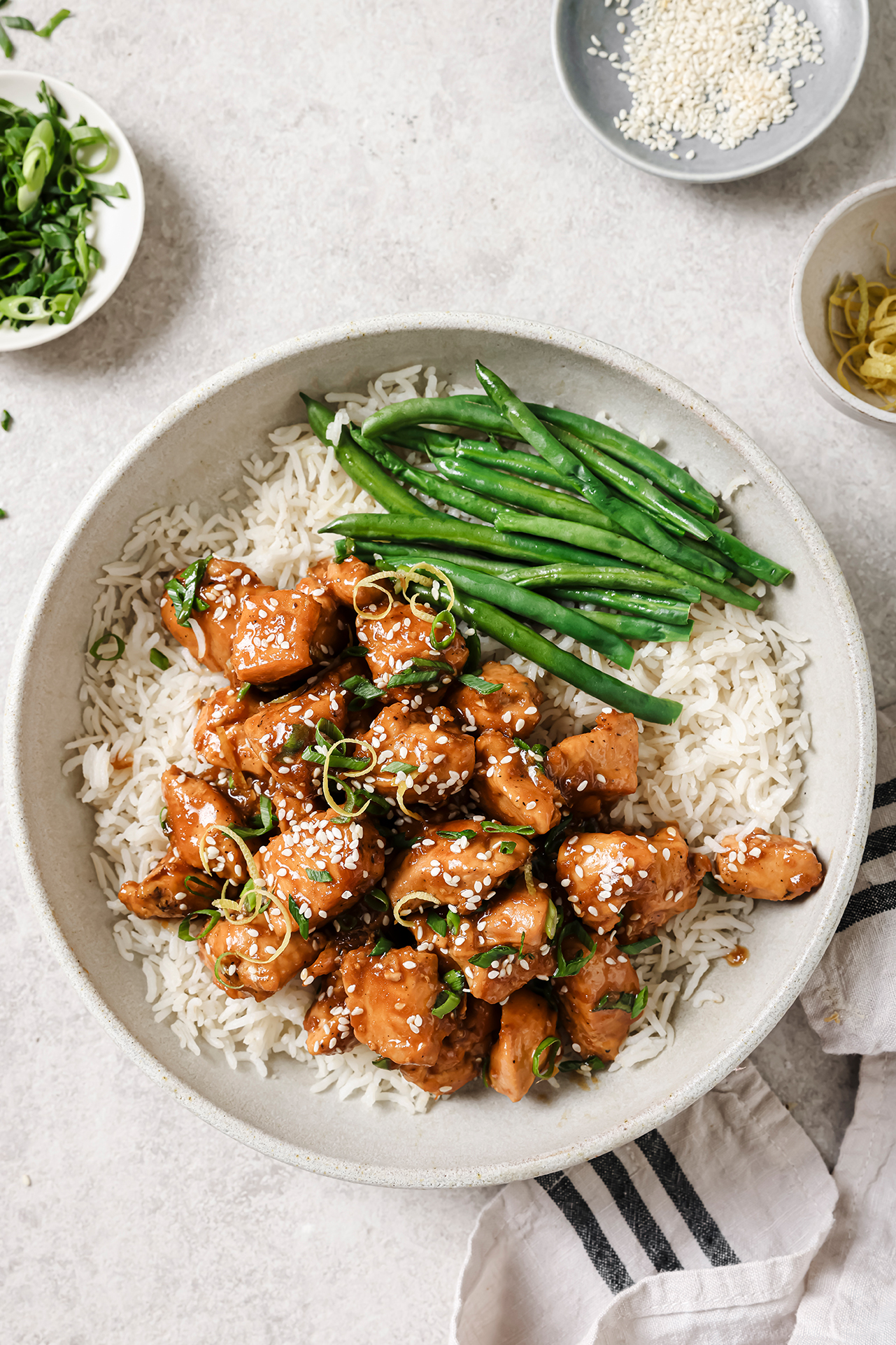 Lemon chicken served over rice and a side of green beans.