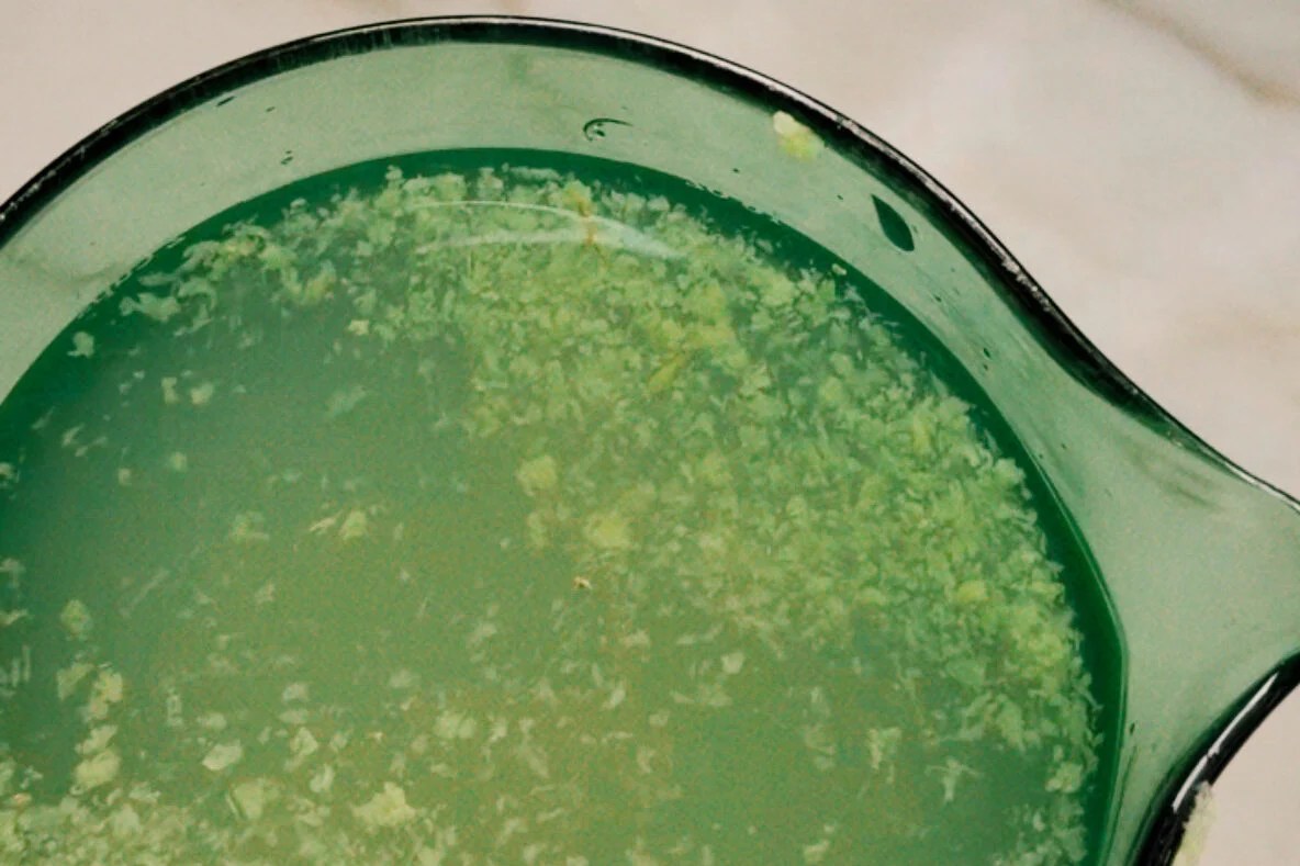 A glass measuring cup of the water, lemonade, and grated ginger mixture.