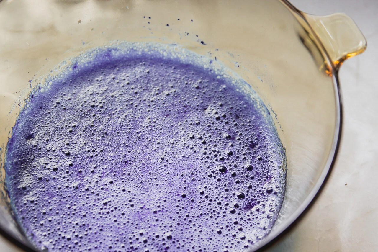 A glass bowl of blue raspberry mixture with gelatin.