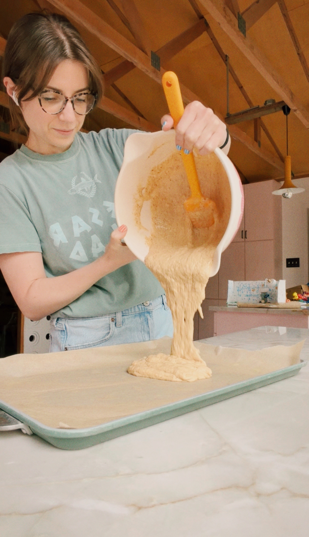 Michelle pouring pancake mix onto a sheet pan.
