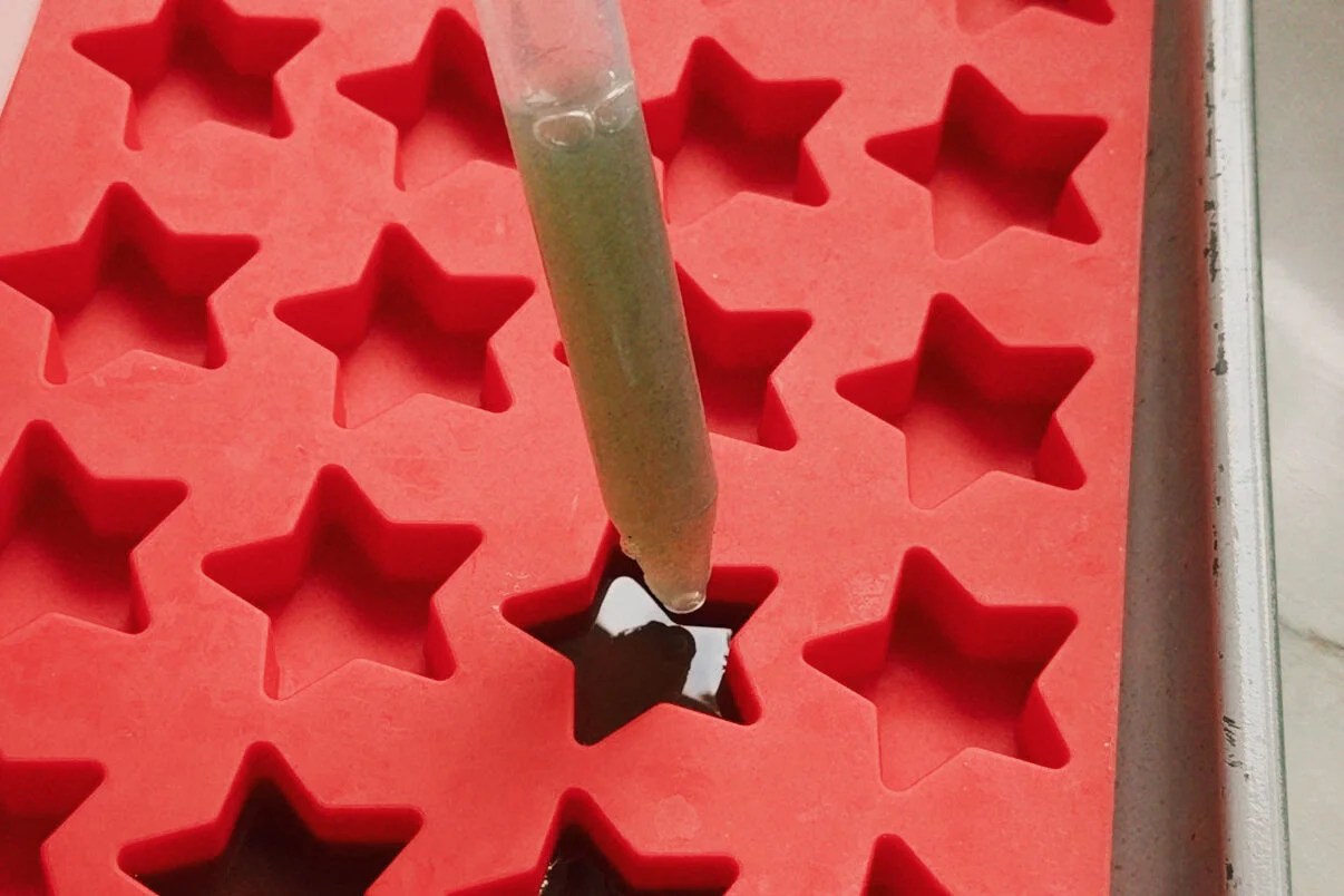 A dropper transferring the gummy to the star mold.