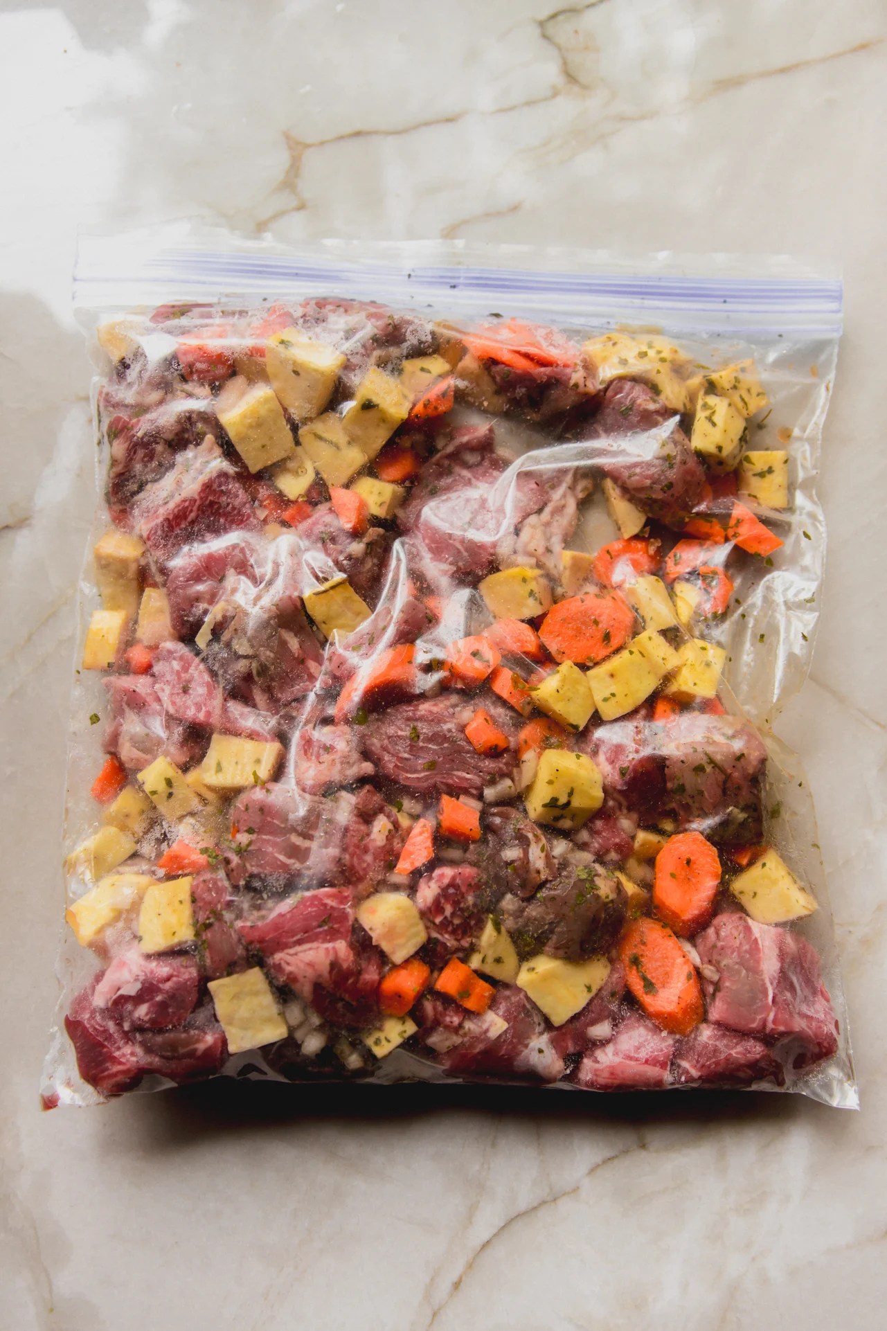 Slow cooker beef stew ingredients uncooked in a freezer bag.
