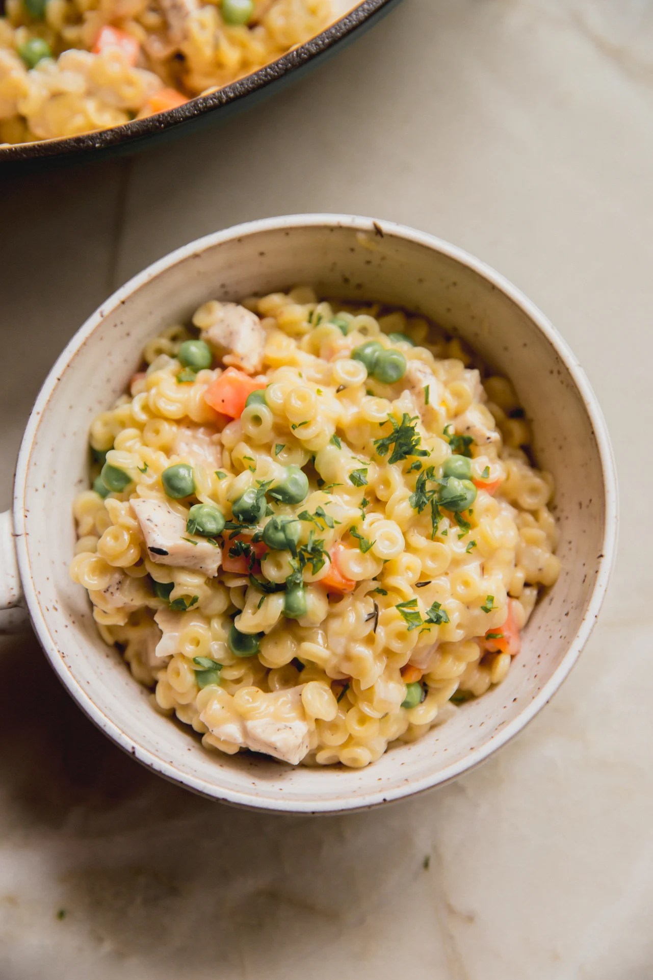 A white ceramic bowl filled with chicken pot pie spaghettios.
