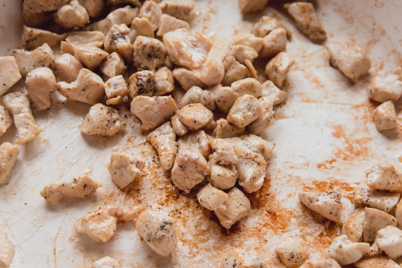 A pan with chicken pieces sauting in it.