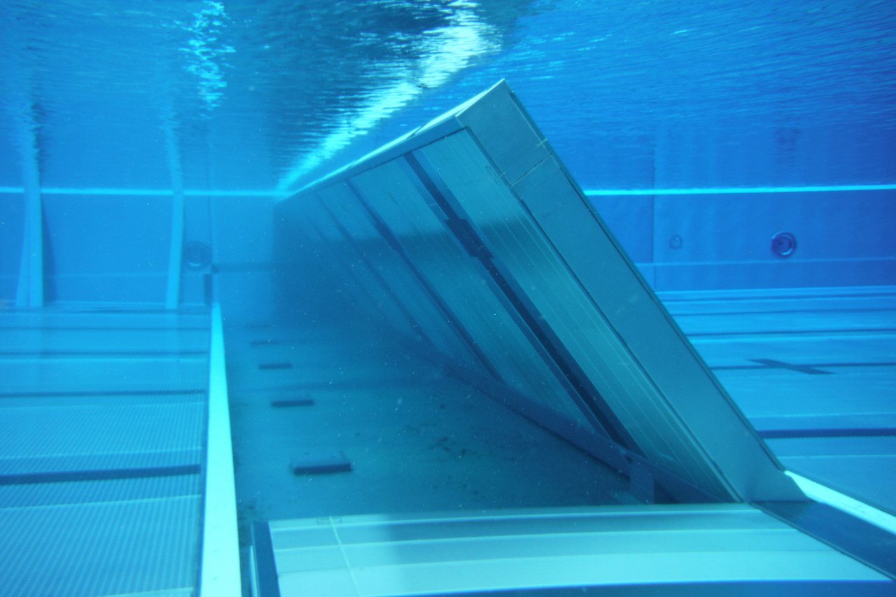 Hinged bulkheads for swimming pools