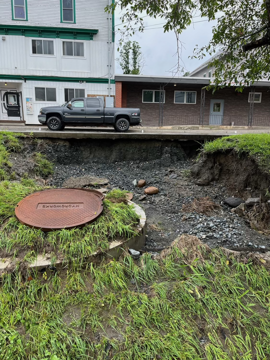 a manhole with a truck in front of it.