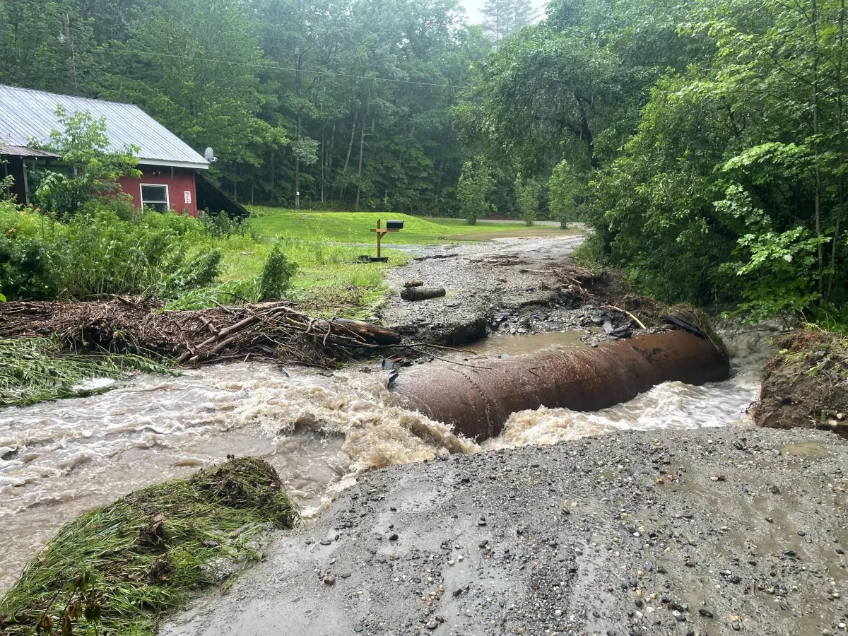 a flooded road with a red building in the background.