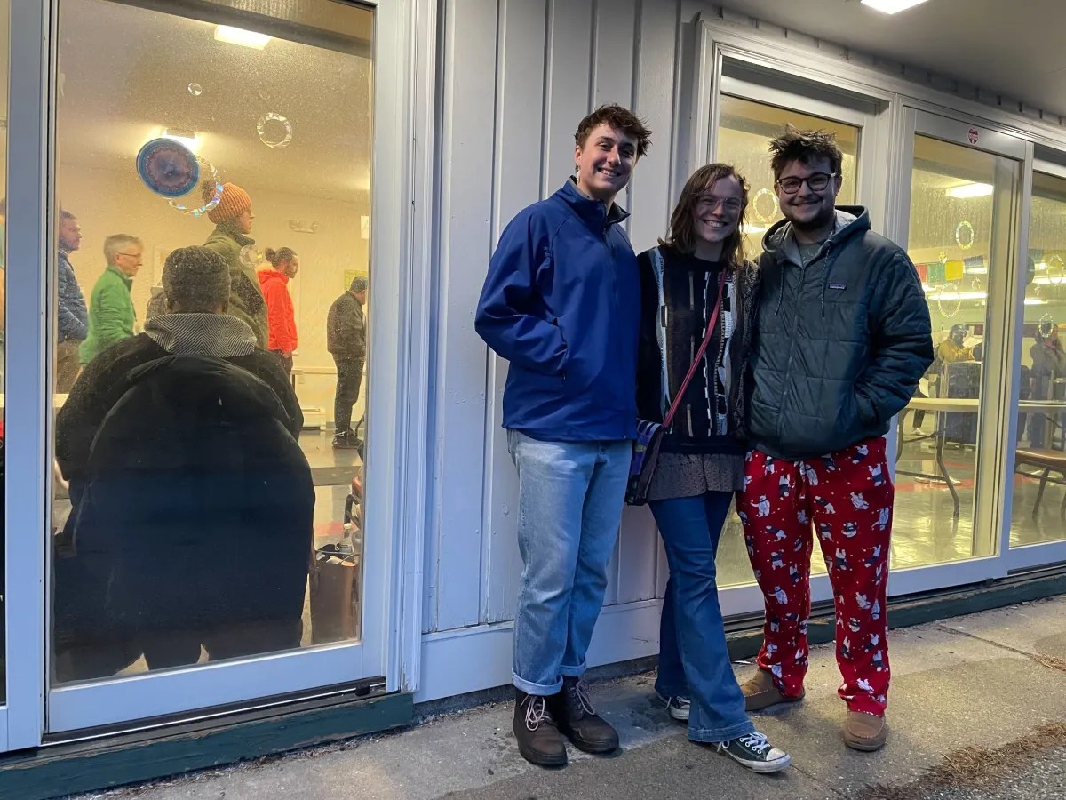 Three people standing in front of a building.