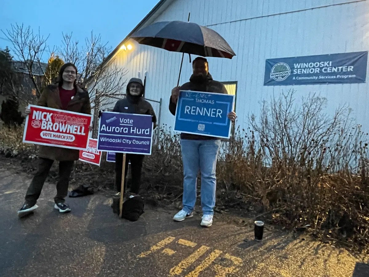 A group of people holding signs in front of a building.