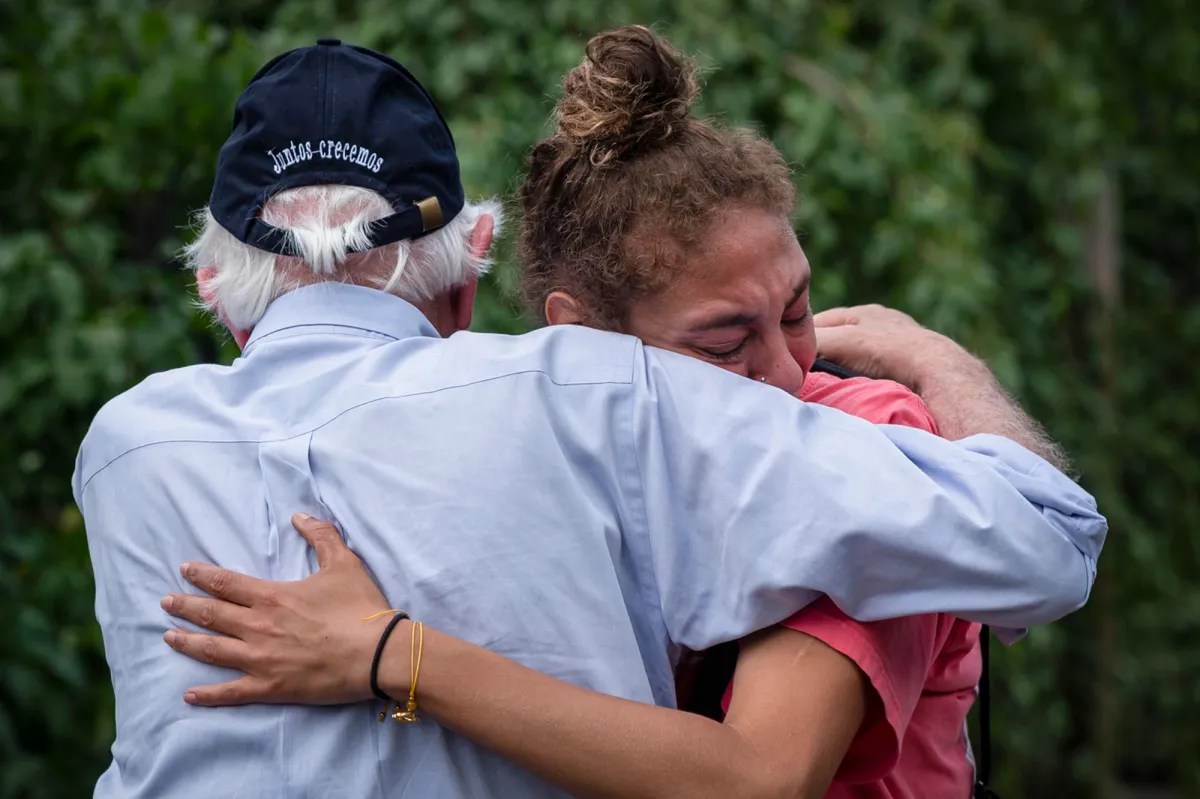 an older man is hugging a young woman.