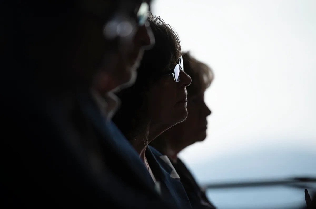 Silhouetted individuals wearing sunglasses in a backlit setting.