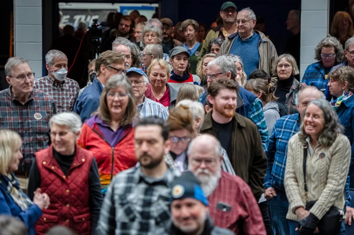 A crowd of people walking through a building.