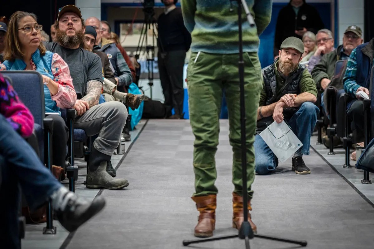 A woman is standing in front of a crowd of people.