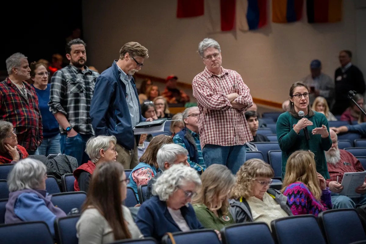 A group of people standing in a large auditorium.