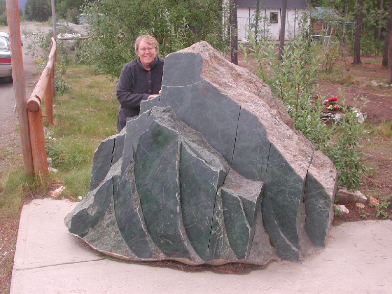 Edith behind a huge jade rock at Jade City on the Cassiar Hwy.