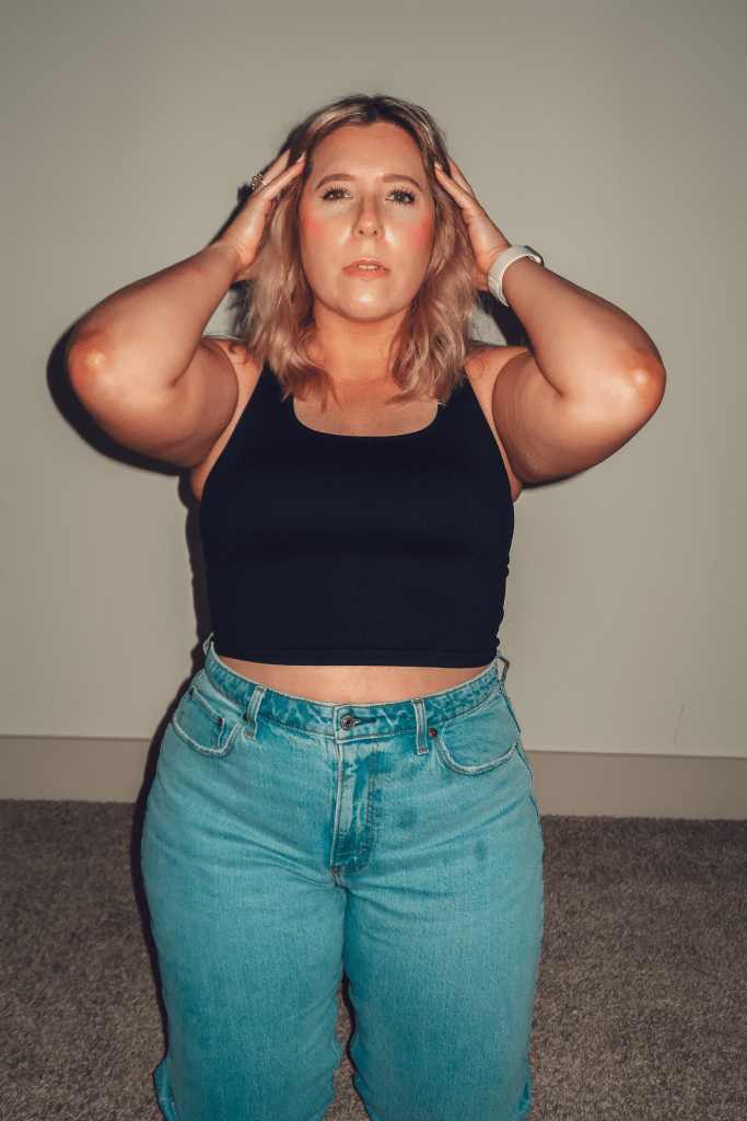 What Savvy Said Blogger Savannah Cyree shares How To Do The 75 Love Reset - in photo: Savannah holdign her hair back and wearing black cropped top and jeans