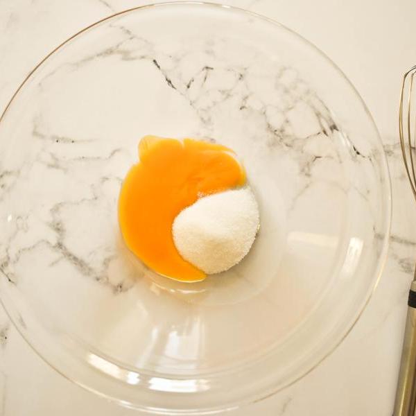 adding sugar to eggs for pastry cream preparation