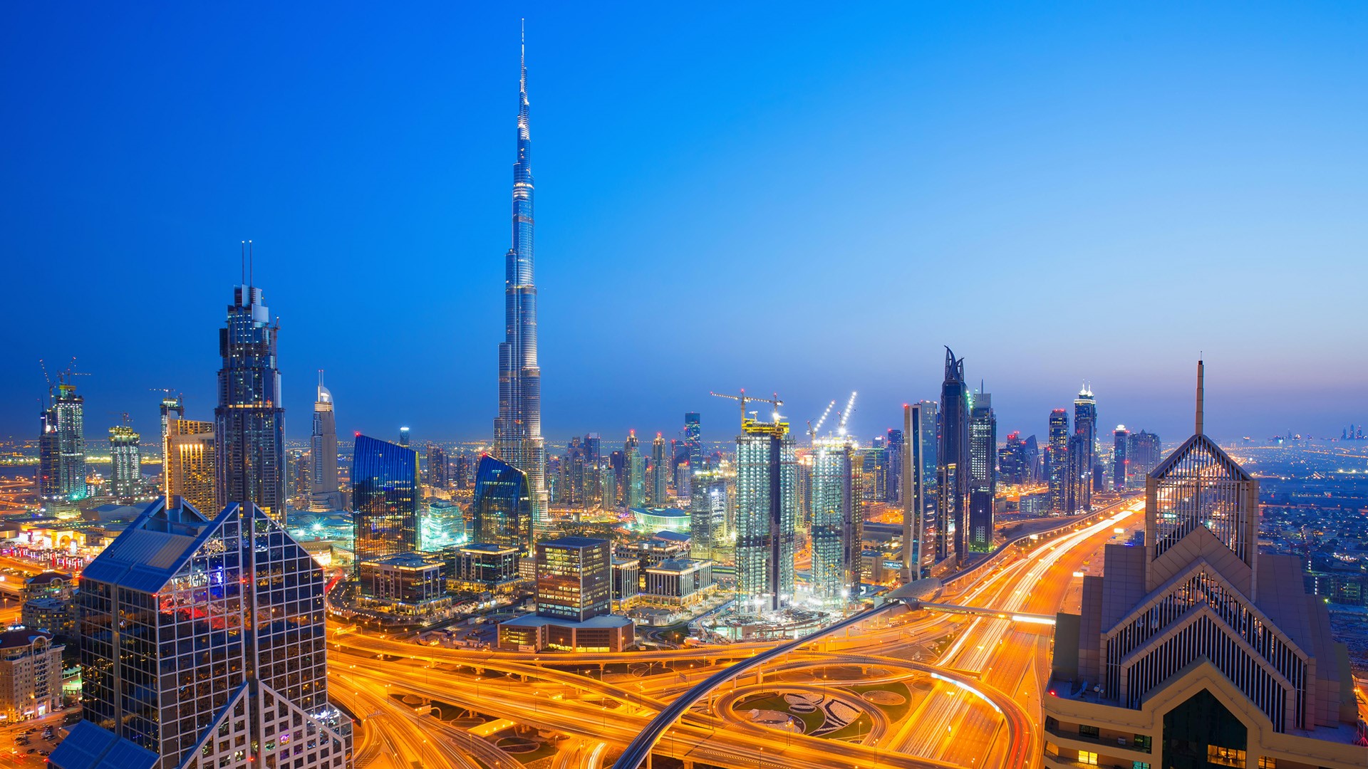 Dubai skyline at sunset with city center lights and Sheikh Zayed road
