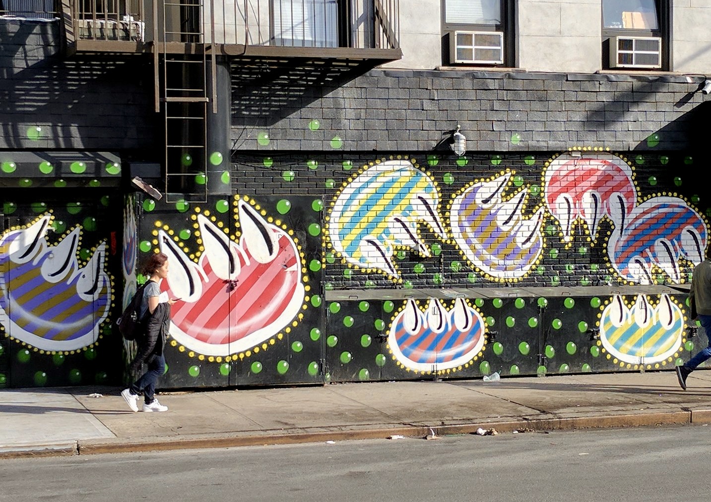Bright colored, stripped claws floating through green bubbles floating up a black wall. Street art that survived.