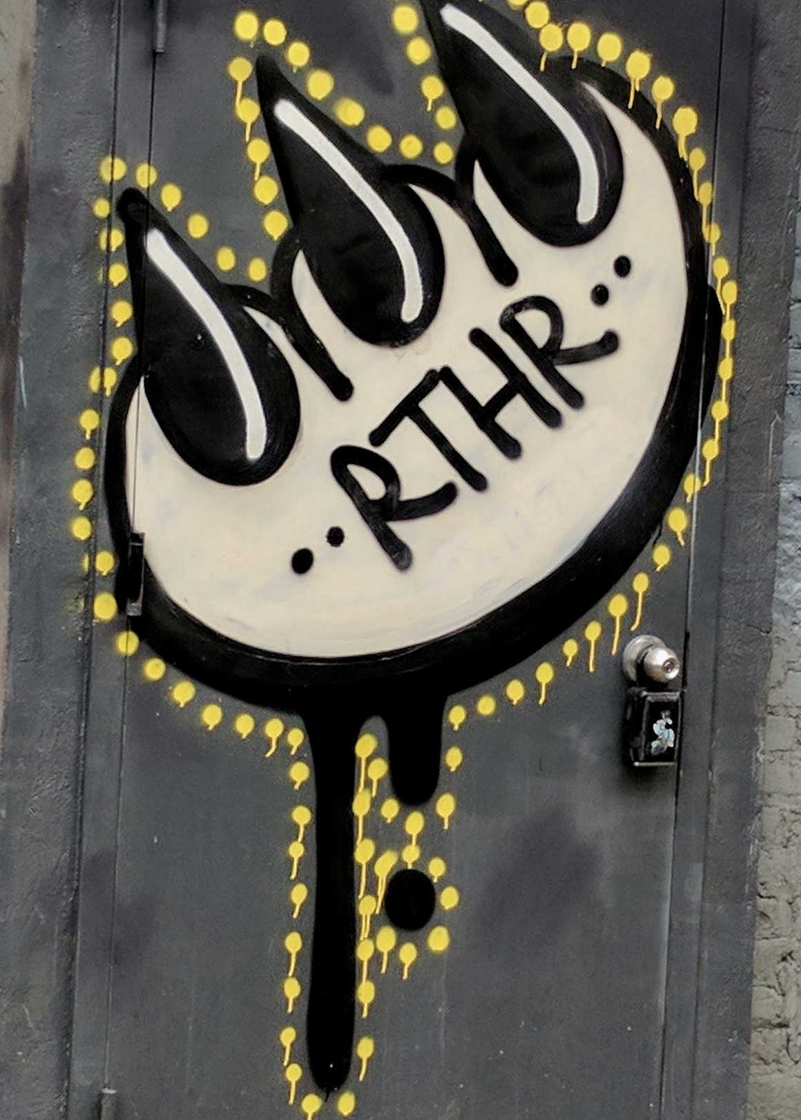 Single Claw emblazoned with RTHR, driping paint and outlines in yellow dots, like perforations. Street art that survived.