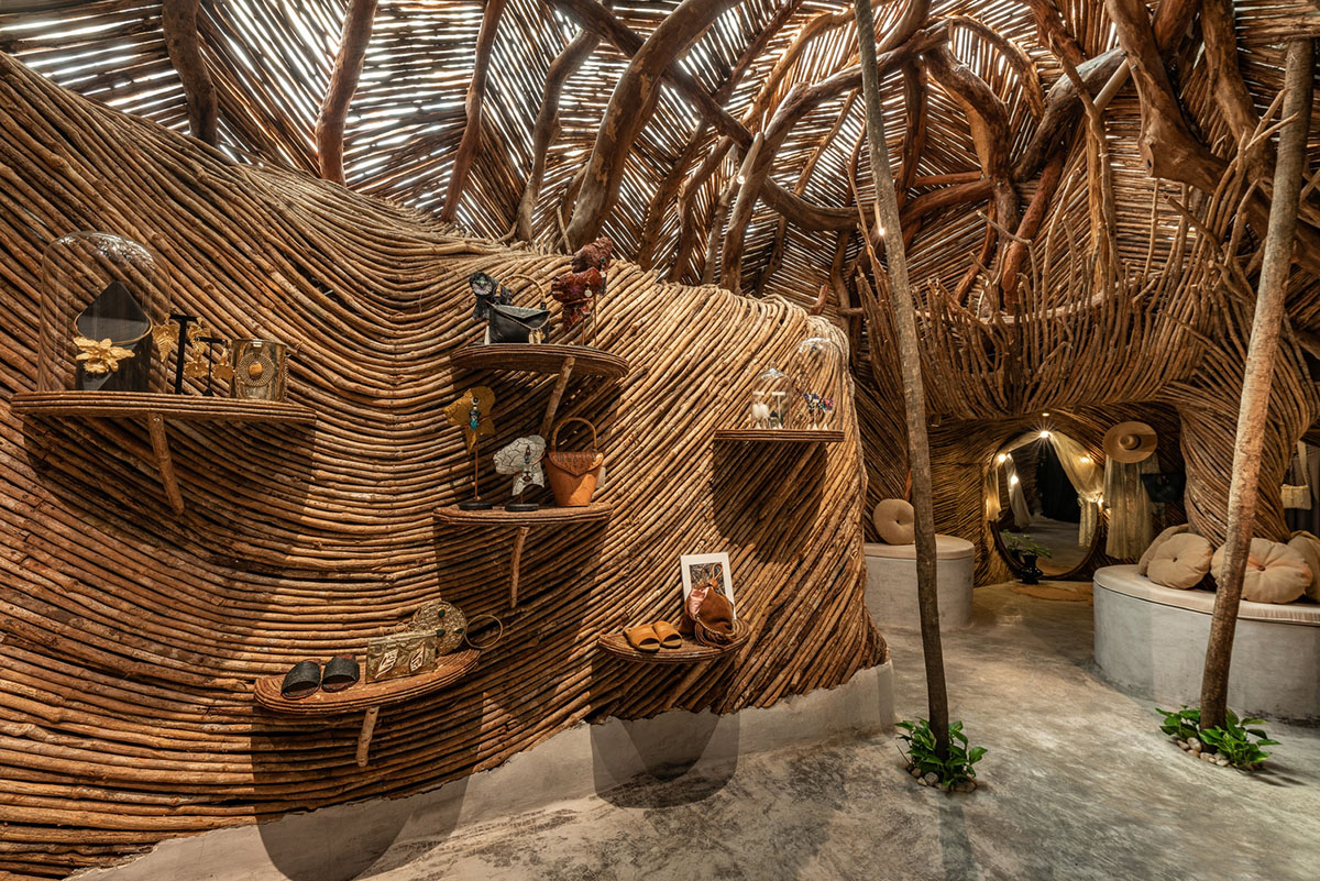 A wooden jungle wraps the interior of a fashion store in Tulum designed