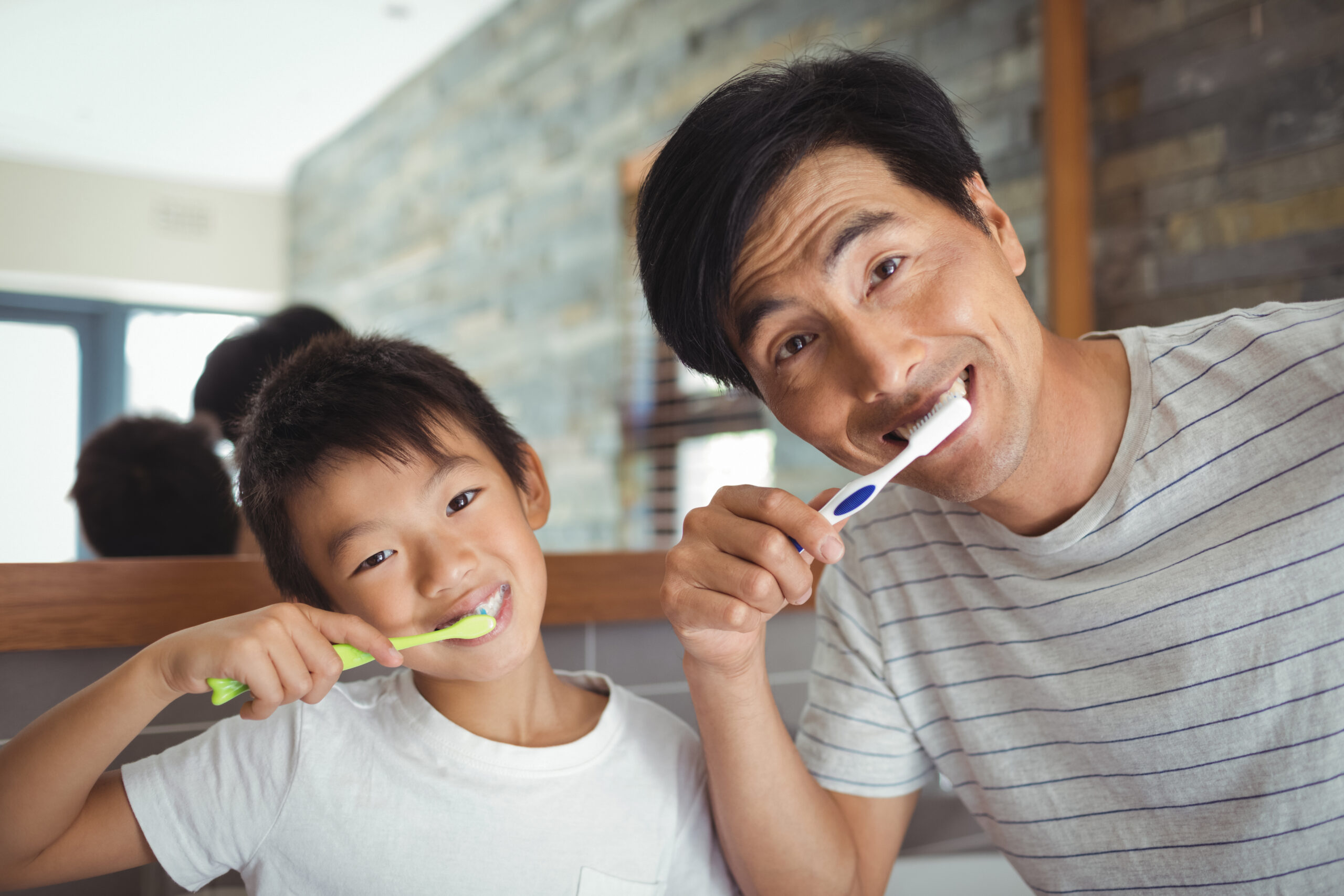 Father and son brushing teeth in the bathroom World