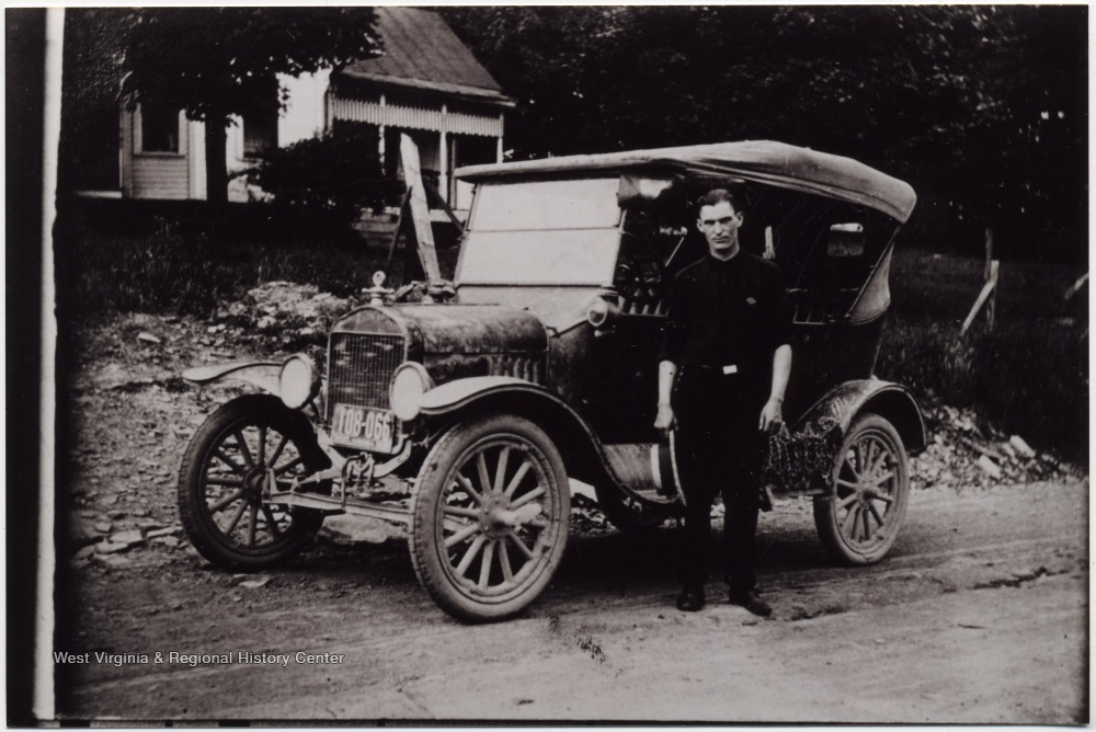Mail Carrier beside his 1927 Chevrolet Roadster, Cowen, W. Va. West