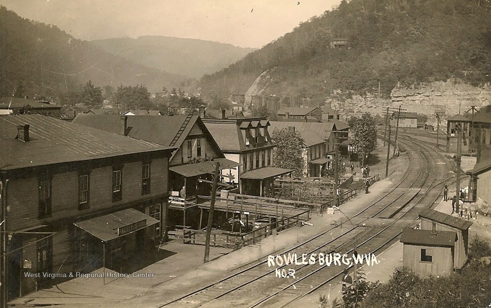 View of Train Tracks Running Behind Racket Store and Other Buildings in