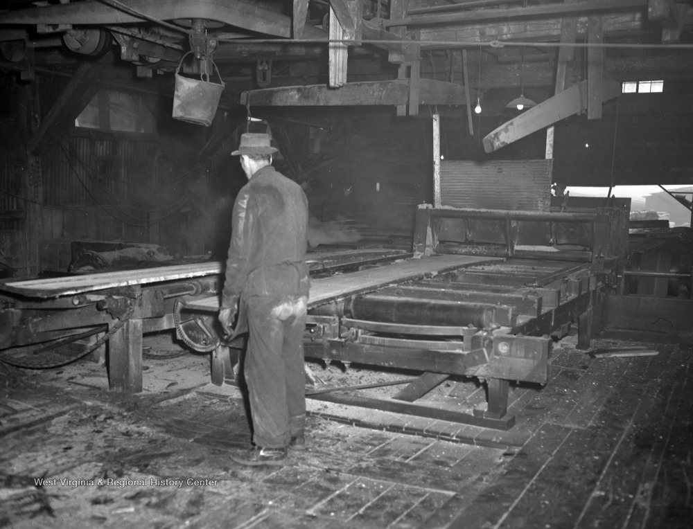 Mower Lumber Co. Employee Pushing Planed Log Through Machinery, Omar, W
