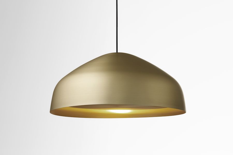 Aura desk lamp directs light thanks to a rotating a golden disk