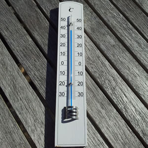 A thermometer on wooden bench