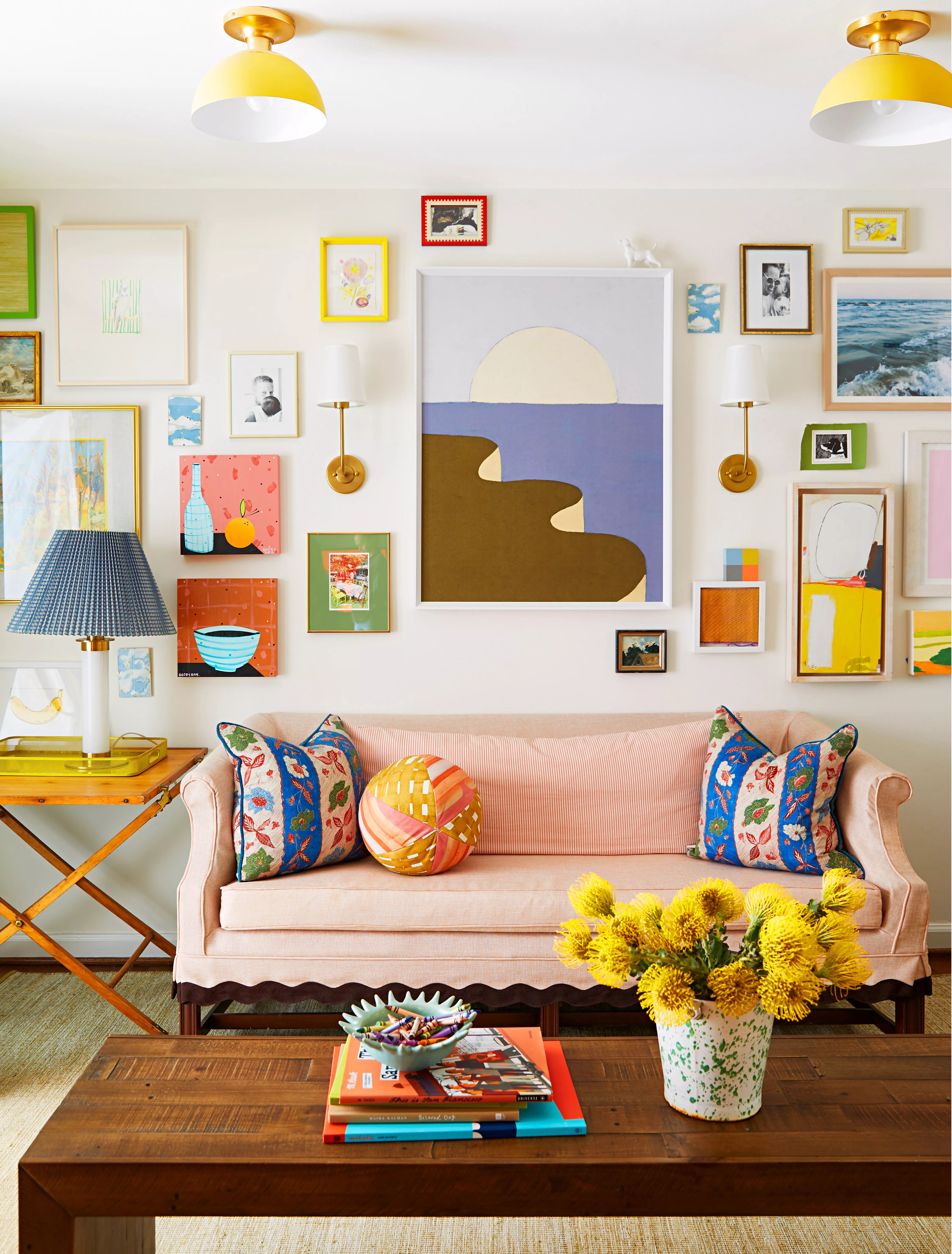 Living room with colorful art and a light pink couch
