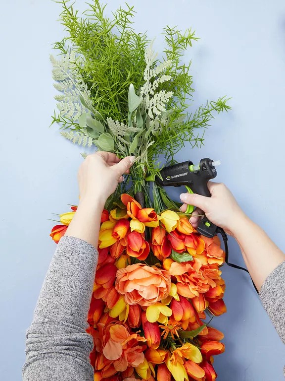 supergluing carrot top greenery to hanging orange bouquet