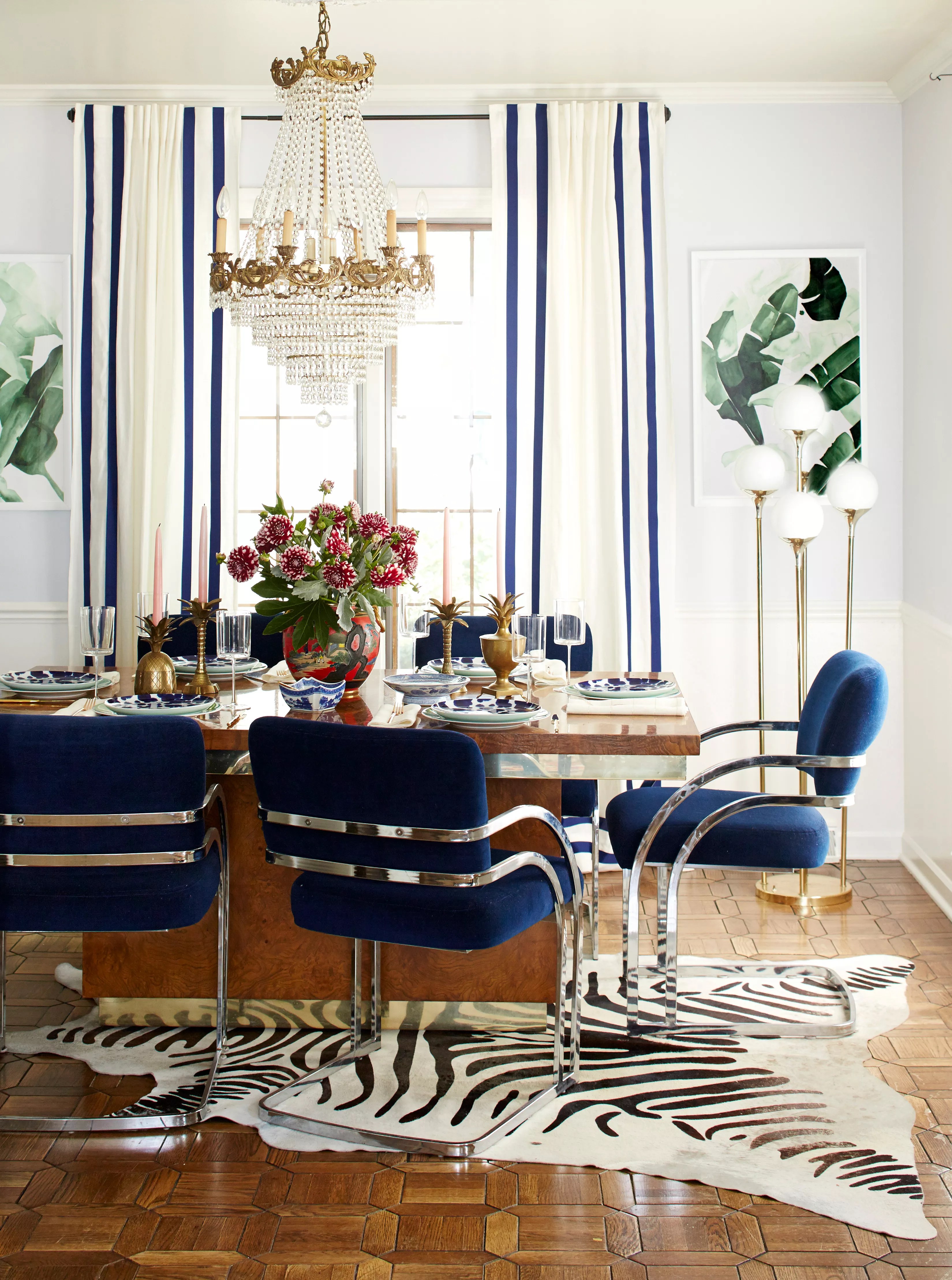 Dining room, navy chairs, curtains, detailed wooden floors, zebra rug; Chandelier over dining table