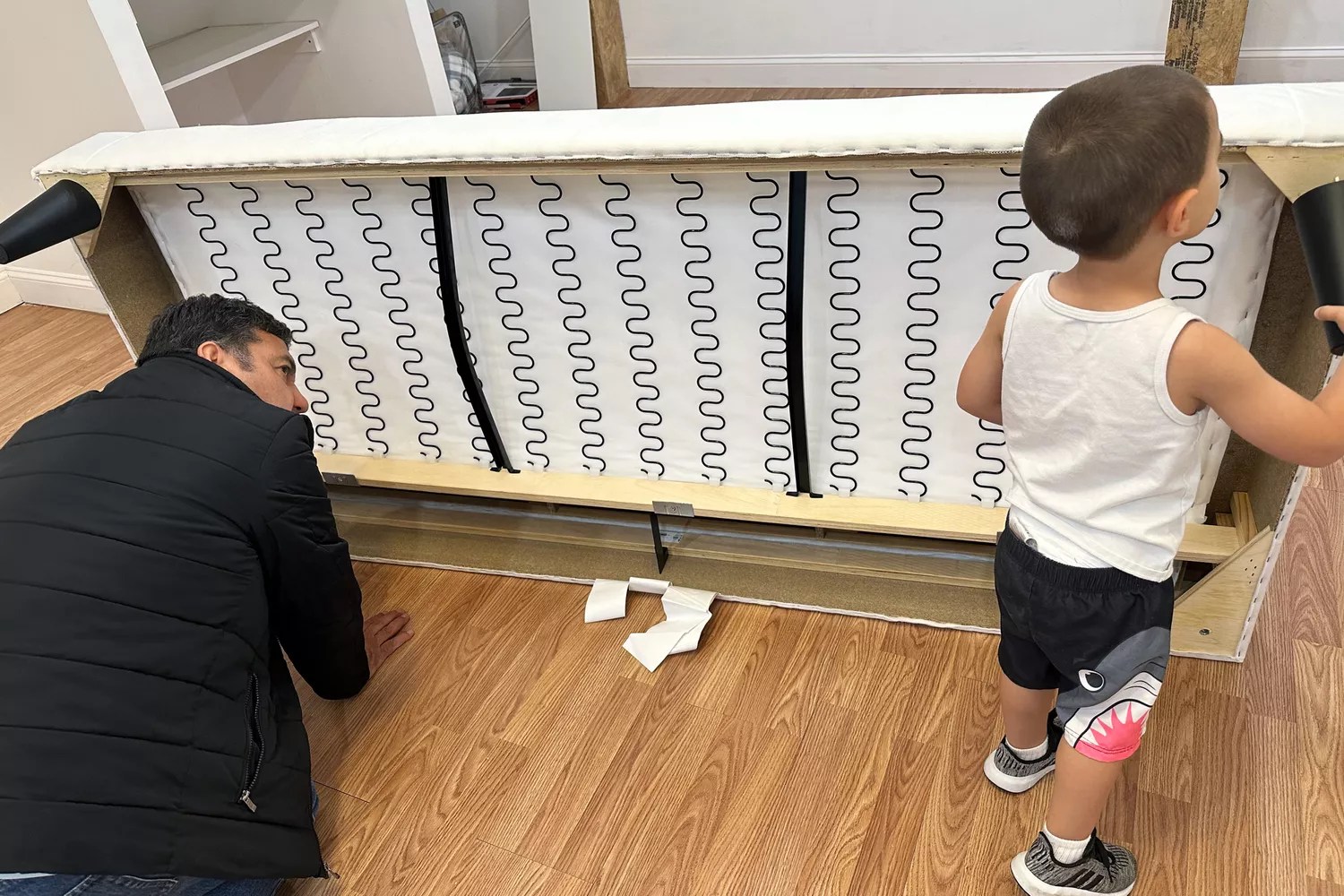 A child and adult inspect the bottom of the IKEA Uppland Sofa