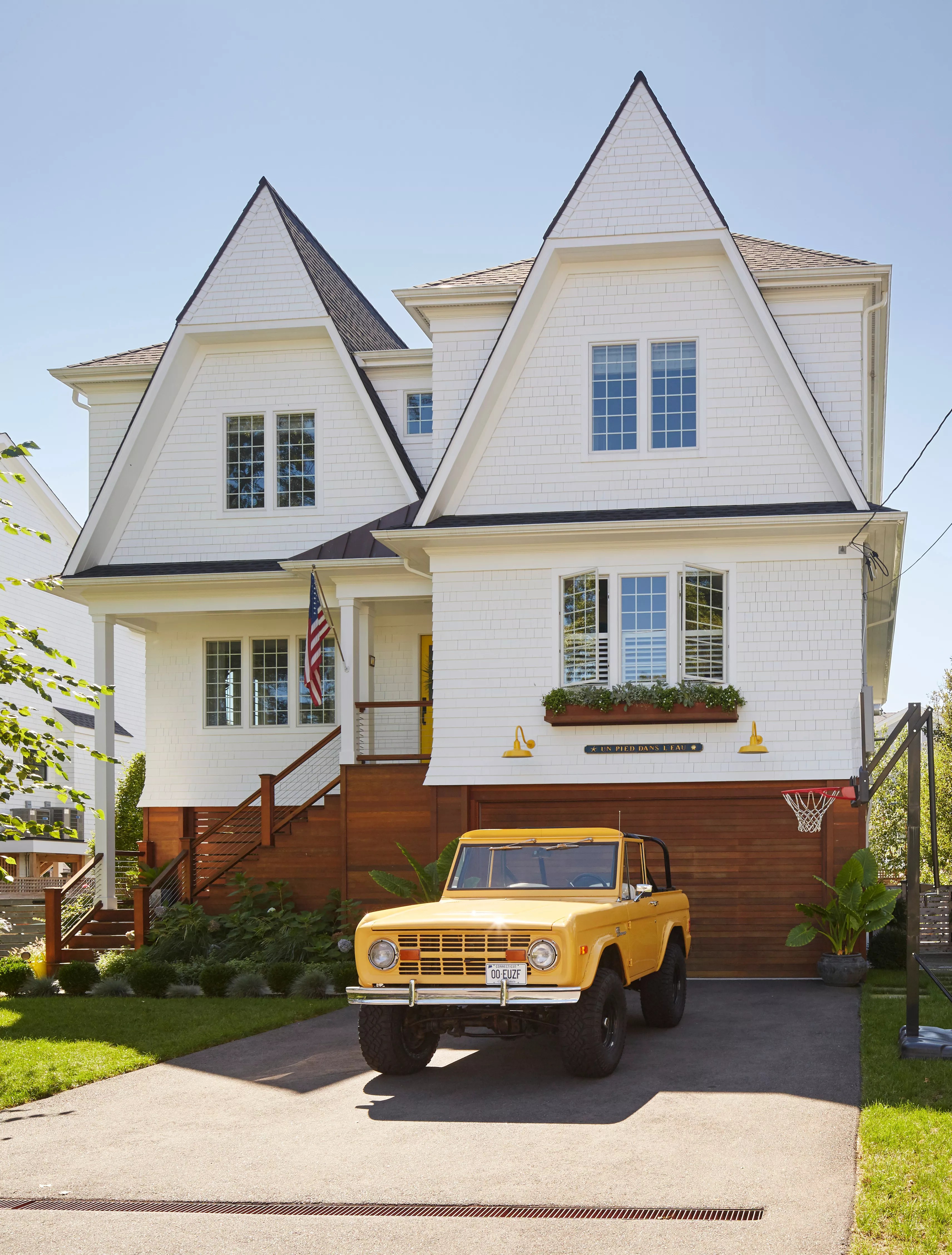 front exterior of house with yellow 1977 Ford Bronco in driveway