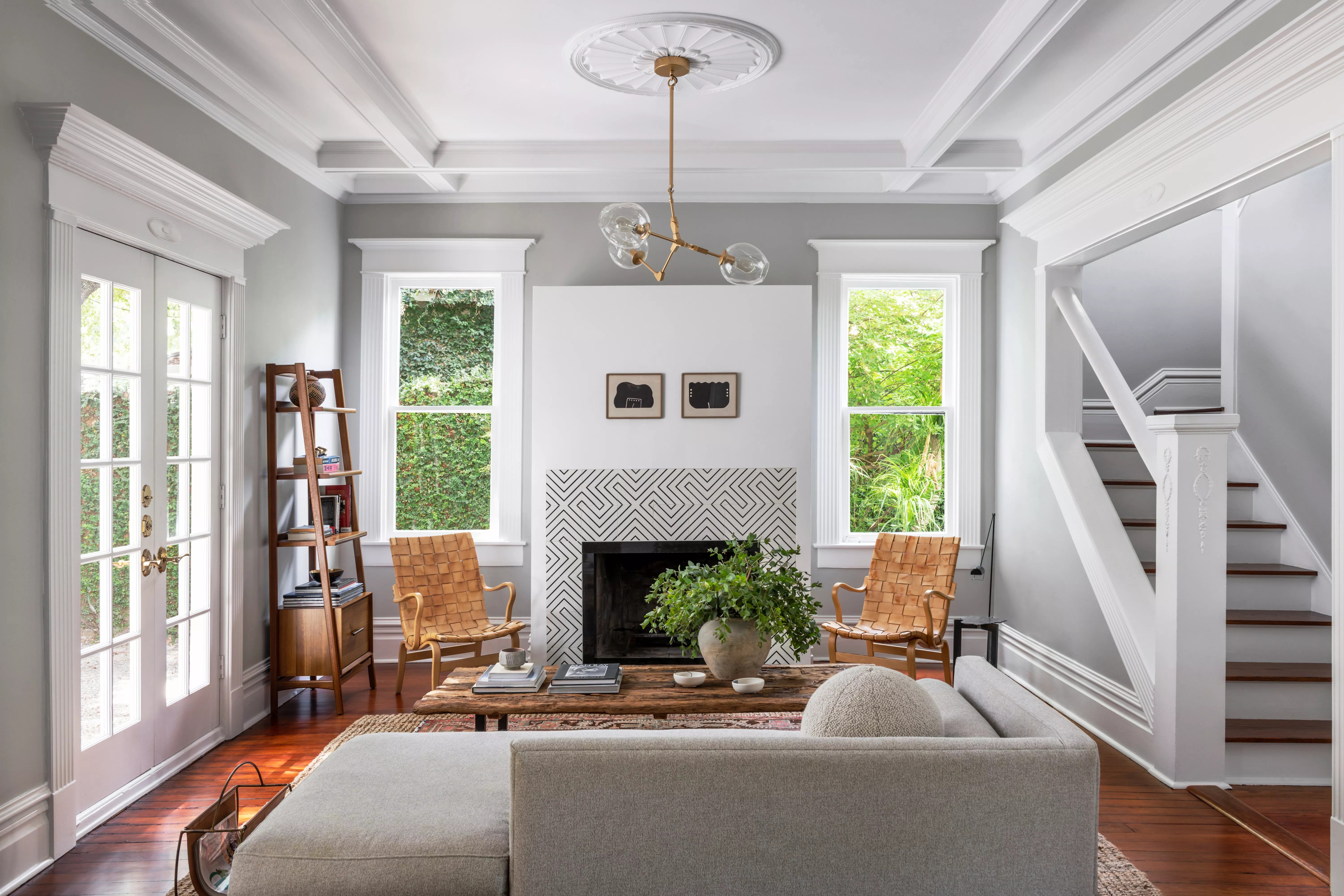 1920s renovated living room with contemporary fireplace, gray walls with white woodwork and hardwood floors
